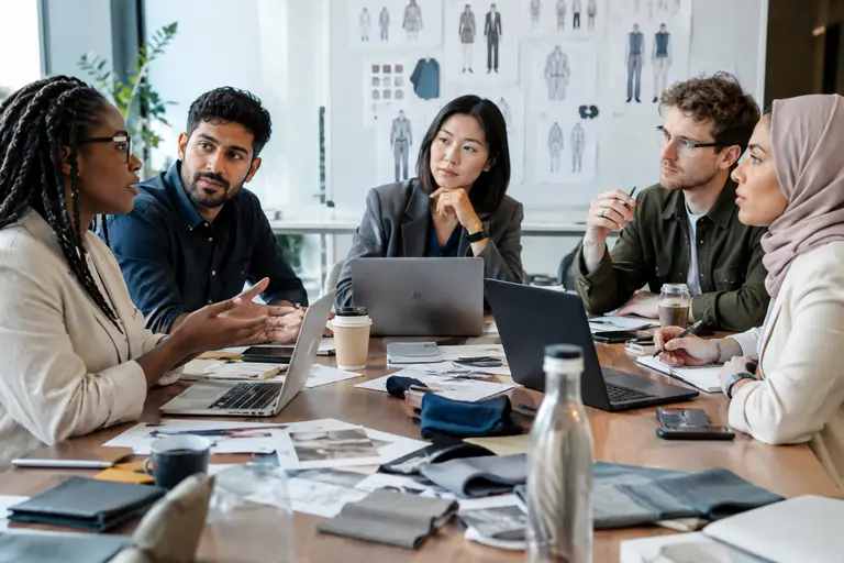 Manager and student discussing notes across a conference table